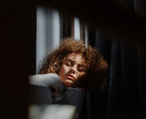 Woman resting her eyes in low light