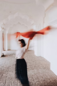 Woman dancing with flowing red fabric