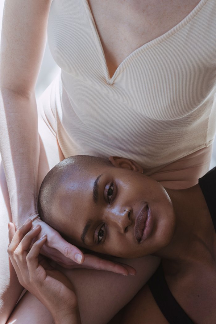 Woman resting her head tenderly in her partner's lap in soft light